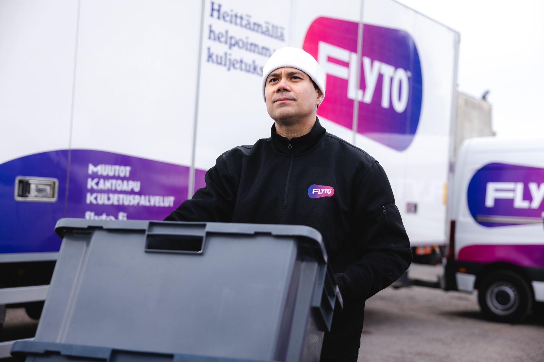 Flyton tiimi kantamassa toimistokalustetta